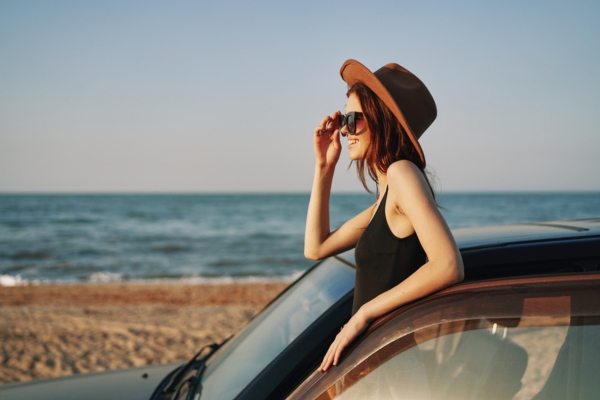 woman driving by the beach depicting summertime