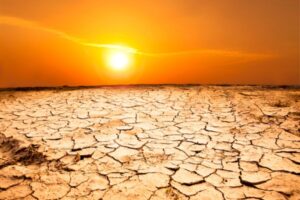 sunset in dry cracked lands depicting intense summer heat