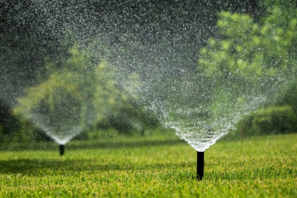 Automatic garden sprinklers near home heating oil tank in summer